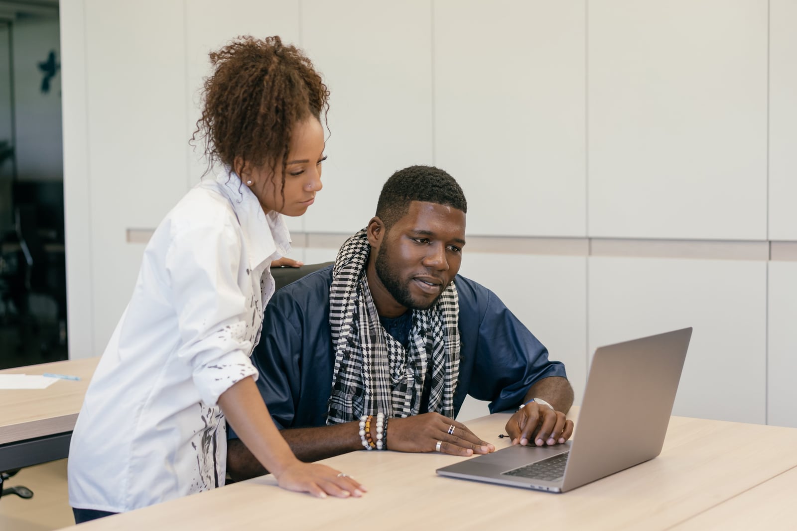 Two professionals reviewing a laptop