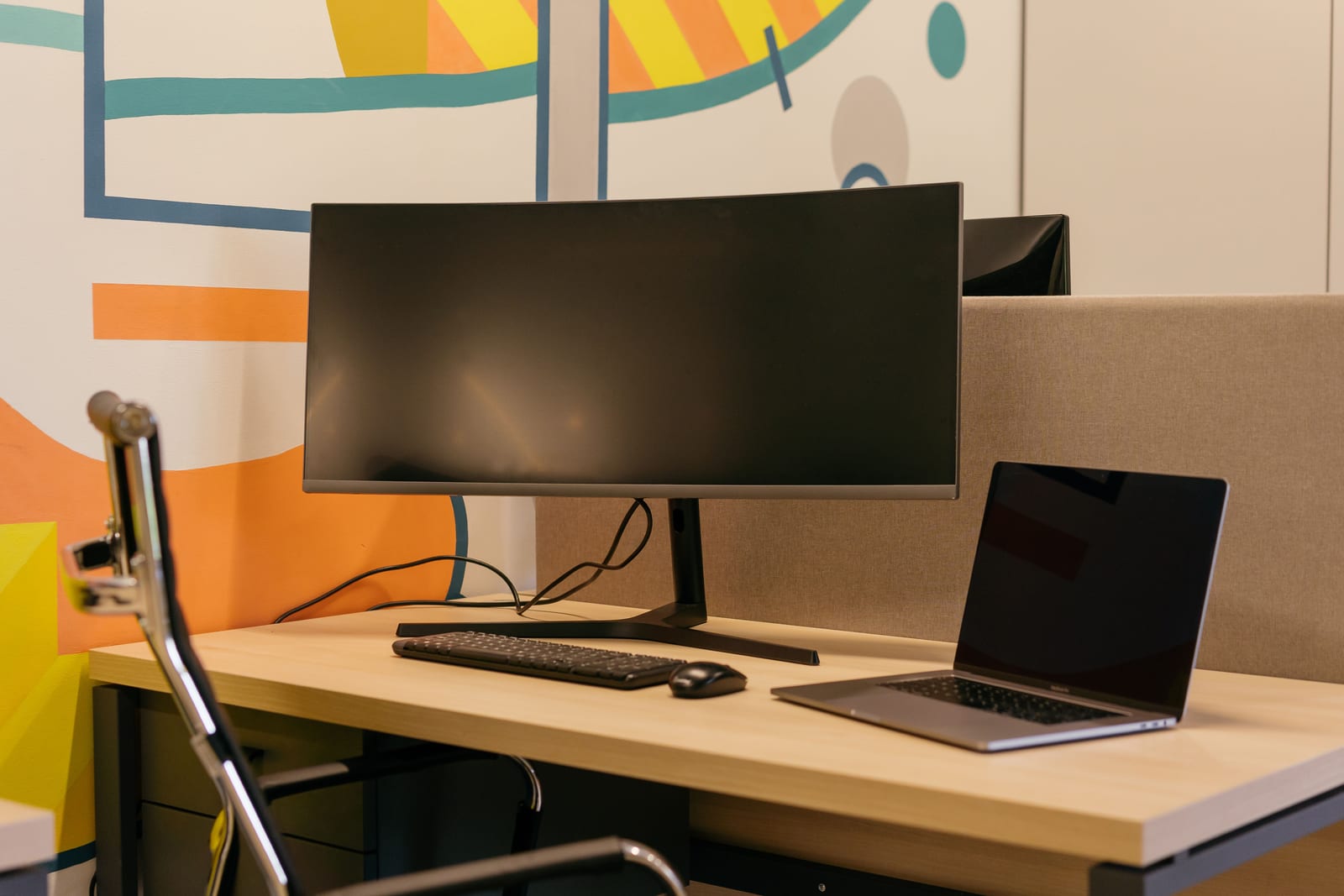 Desktop monitor and laptop in an office workspace