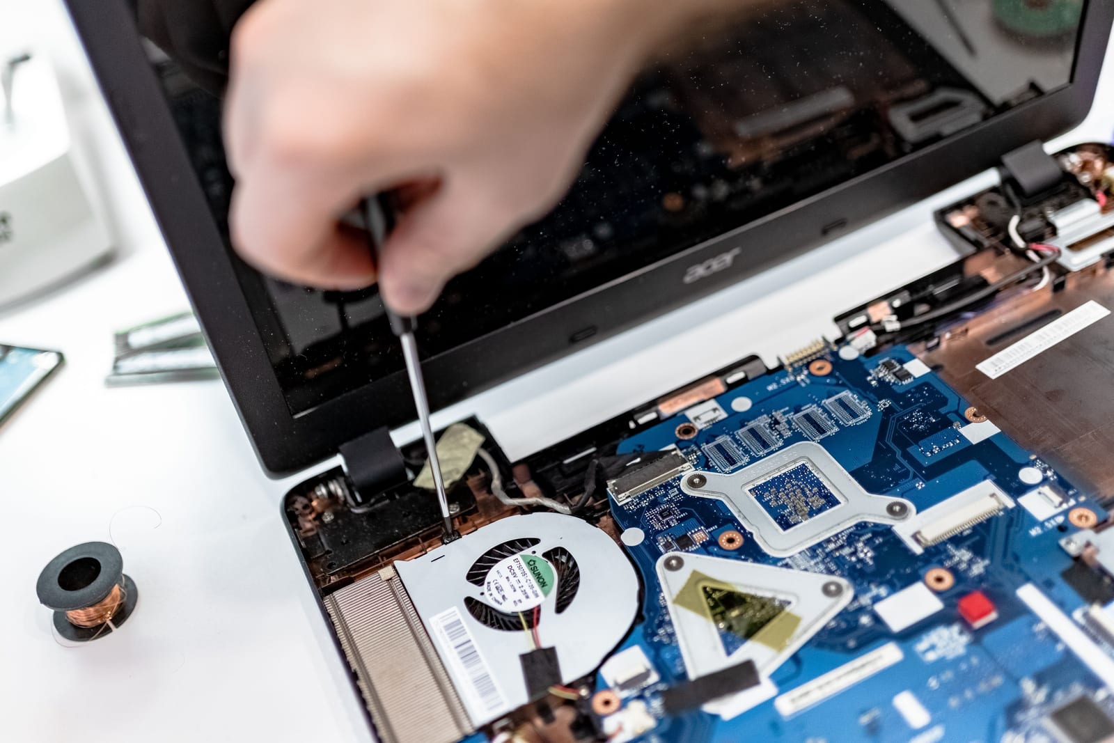 Hands working on the internal components of a laptop