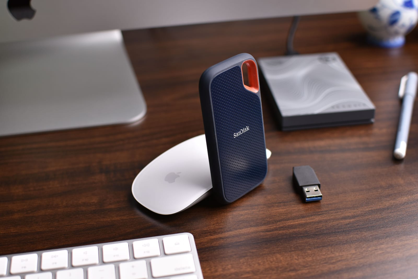 Portable storage and computer accessories on a wooden desk