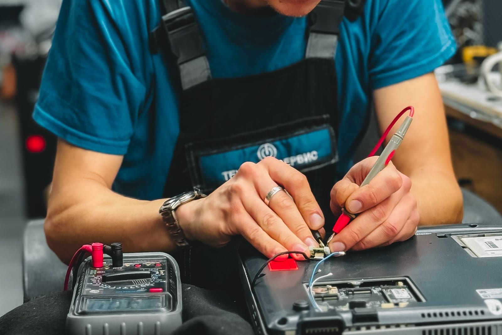 Technician examining a laptop in a repair workshop